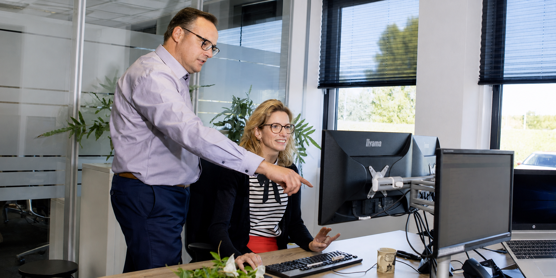 Adviseur en ondernemer bespreken cijfers achter een computerscherm